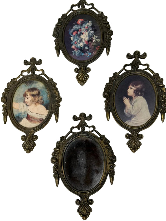 Four ornate picture frames with vintage-style portraits on a textured white surface