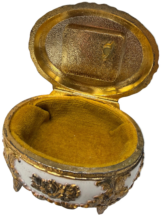 Gold decorative box with intricate designs on a white surface
